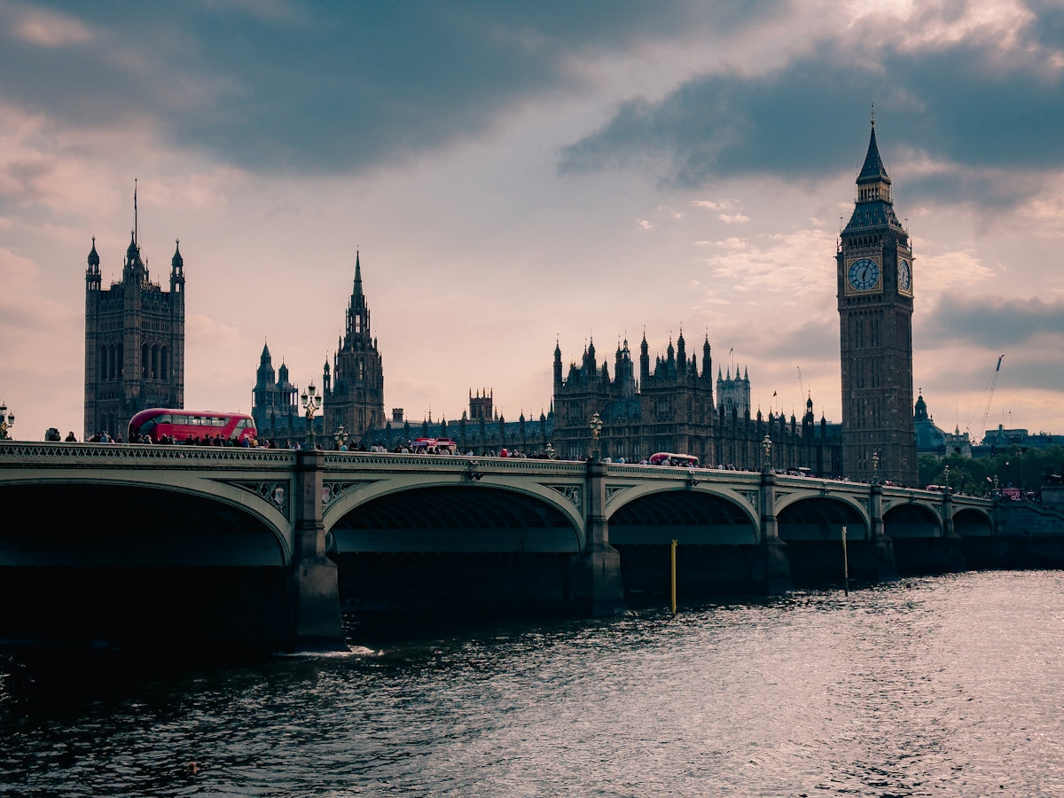 A bridge over a body of water with a clock tower in the background